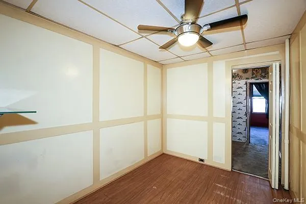a view of a hallway with wooden floor and a kitchen