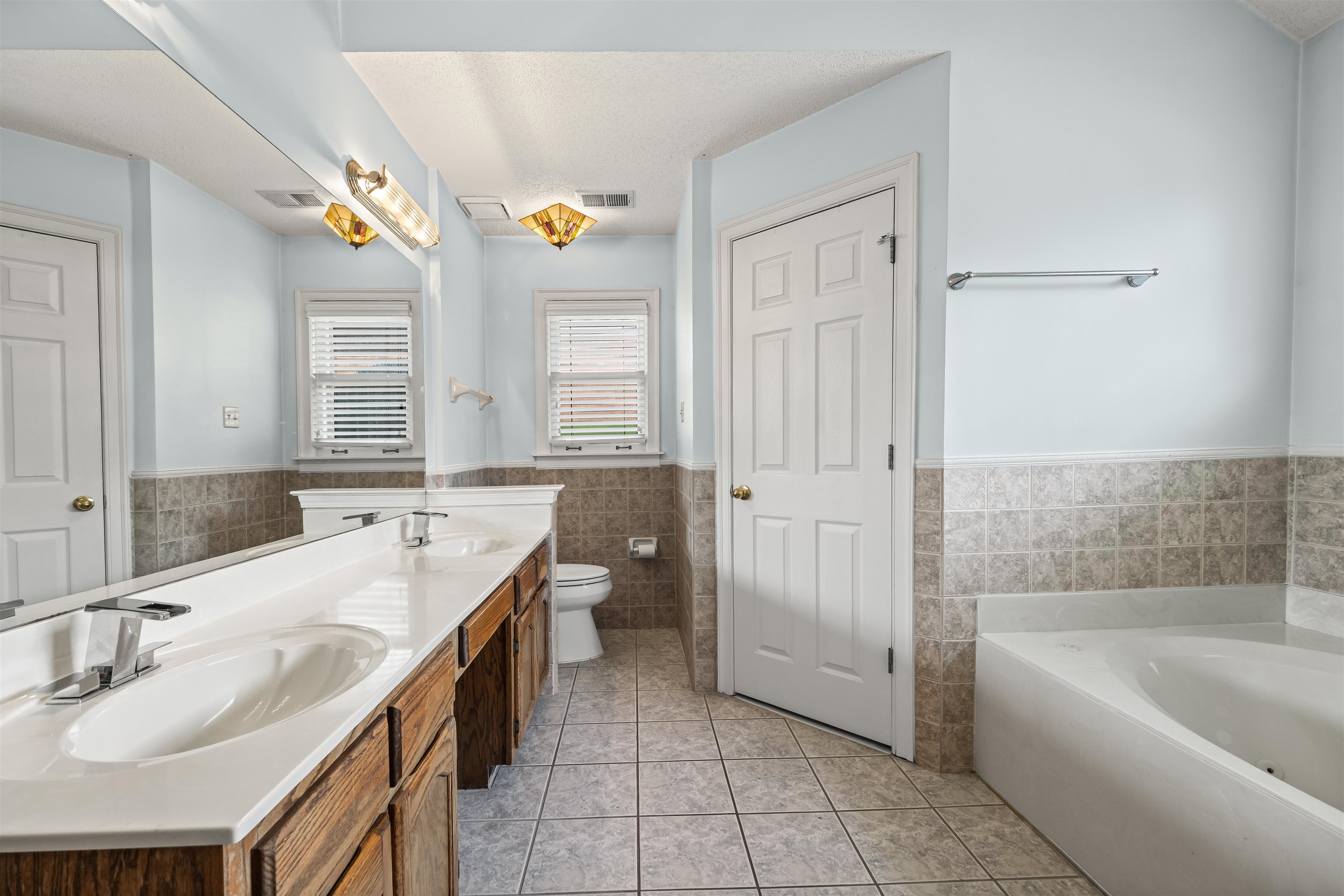 8645 Bazemore Road Memphis, TN 38018 - Photo 18 of 28 Full bathroom with tile walls, wainscoting, double vanity, a garden tub, and tile patterned flooring