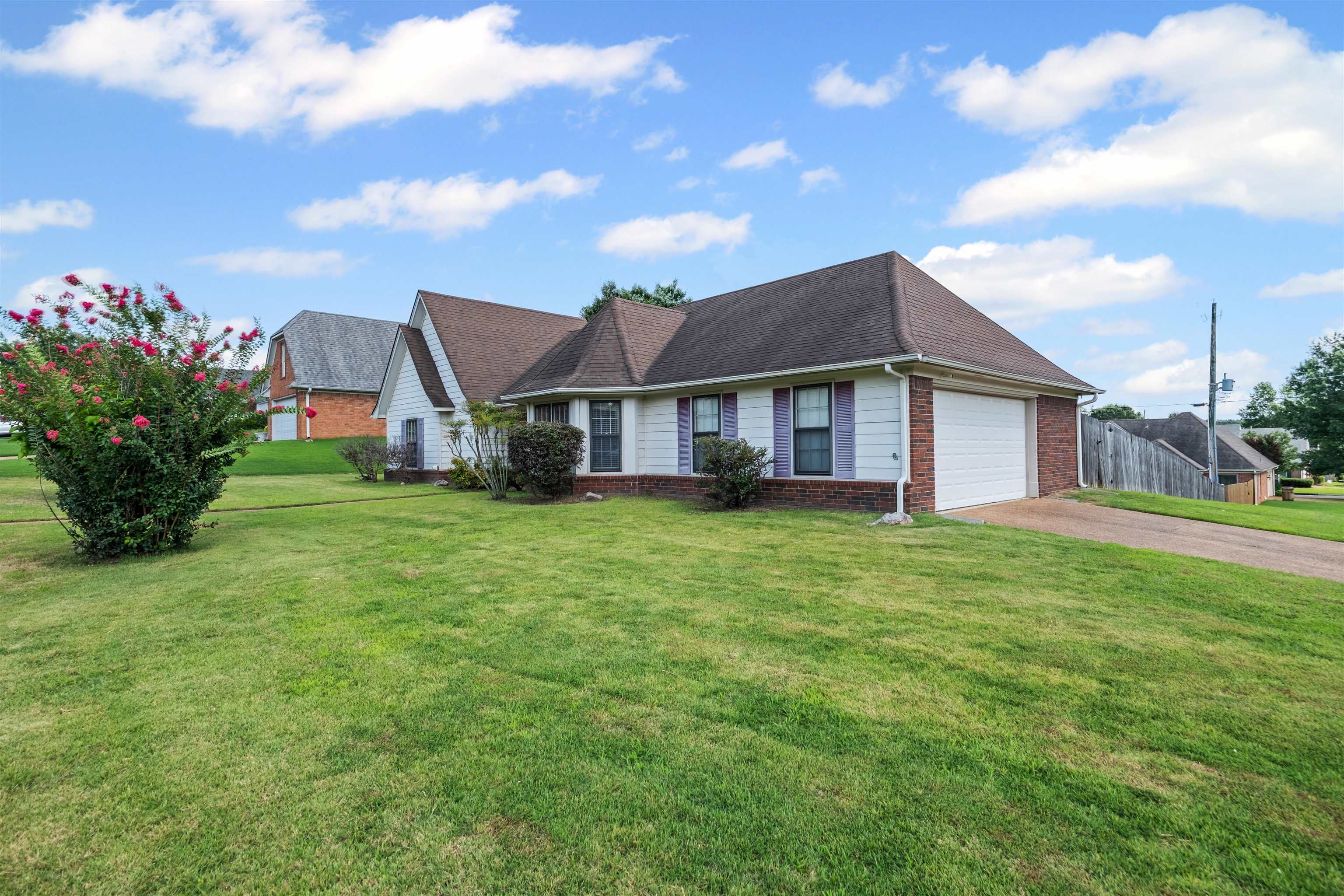 8645 Bazemore Road Memphis, TN 38018 - Photo 3 of 28 View of front of property featuring brick siding, an attached garage, driveway, and a shingled roof