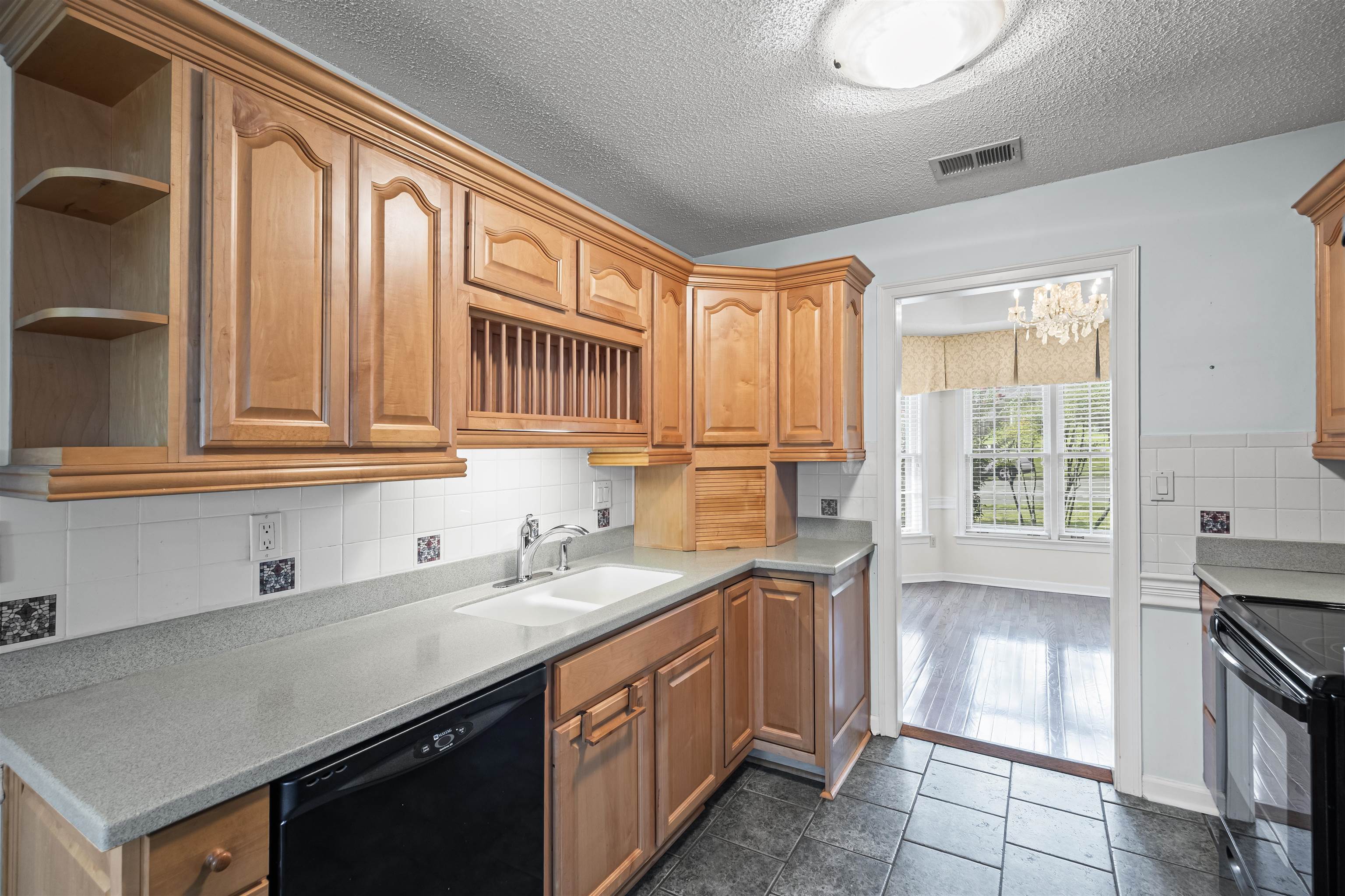 8645 Bazemore Road Memphis, TN 38018 - Photo 8 of 28 Kitchen with open shelves, black appliances, tasteful backsplash, a chandelier, and a textured ceiling