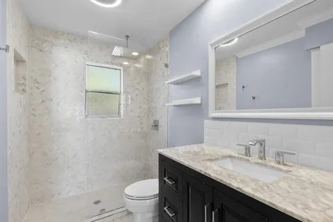 a bathroom with a sink a toilet and shower