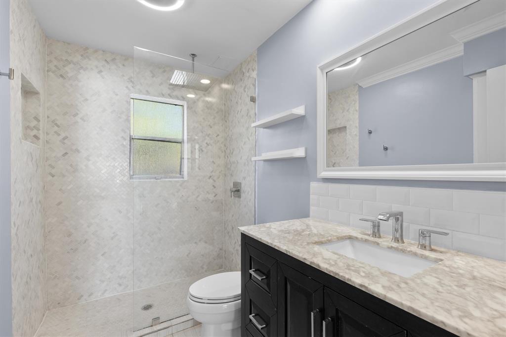 3012 Mahanna Springs Drive, Unit A Dallas, TX 75235 - Photo 17 of 29 a bathroom with a granite countertop sink a toilet and a mirror