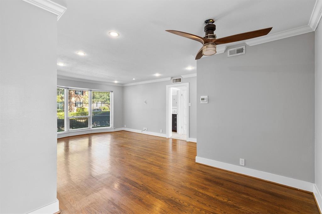 3012 Mahanna Springs Drive, Unit A Dallas, TX 75235 - Photo 8 of 29 a view of an empty room with wooden floor and a window