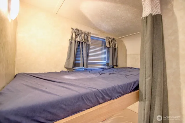 a bed sitting in a bedroom next to a window