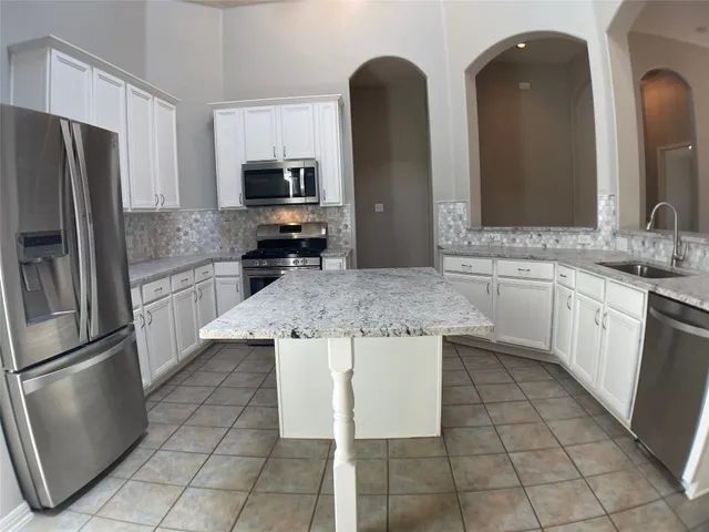 an empty room with wooden floor and a fireplace