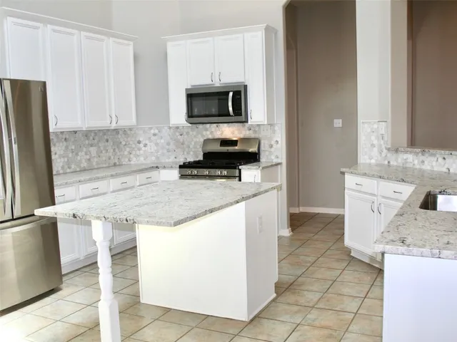 a kitchen with stainless steel appliances a sink stove and refrigerator