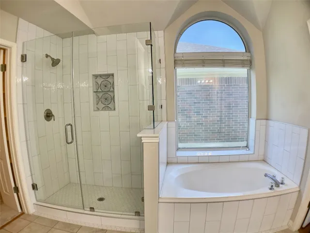 a bathroom with a double vanity sink a mirror and a bathtub
