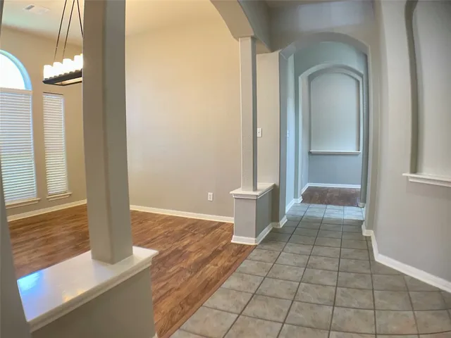 a view of a hallway with wooden floor and a living room