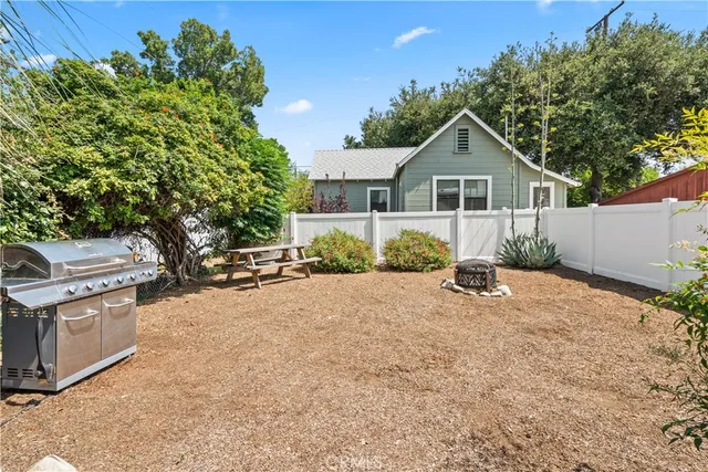 a view of a house with a yard and potted plants