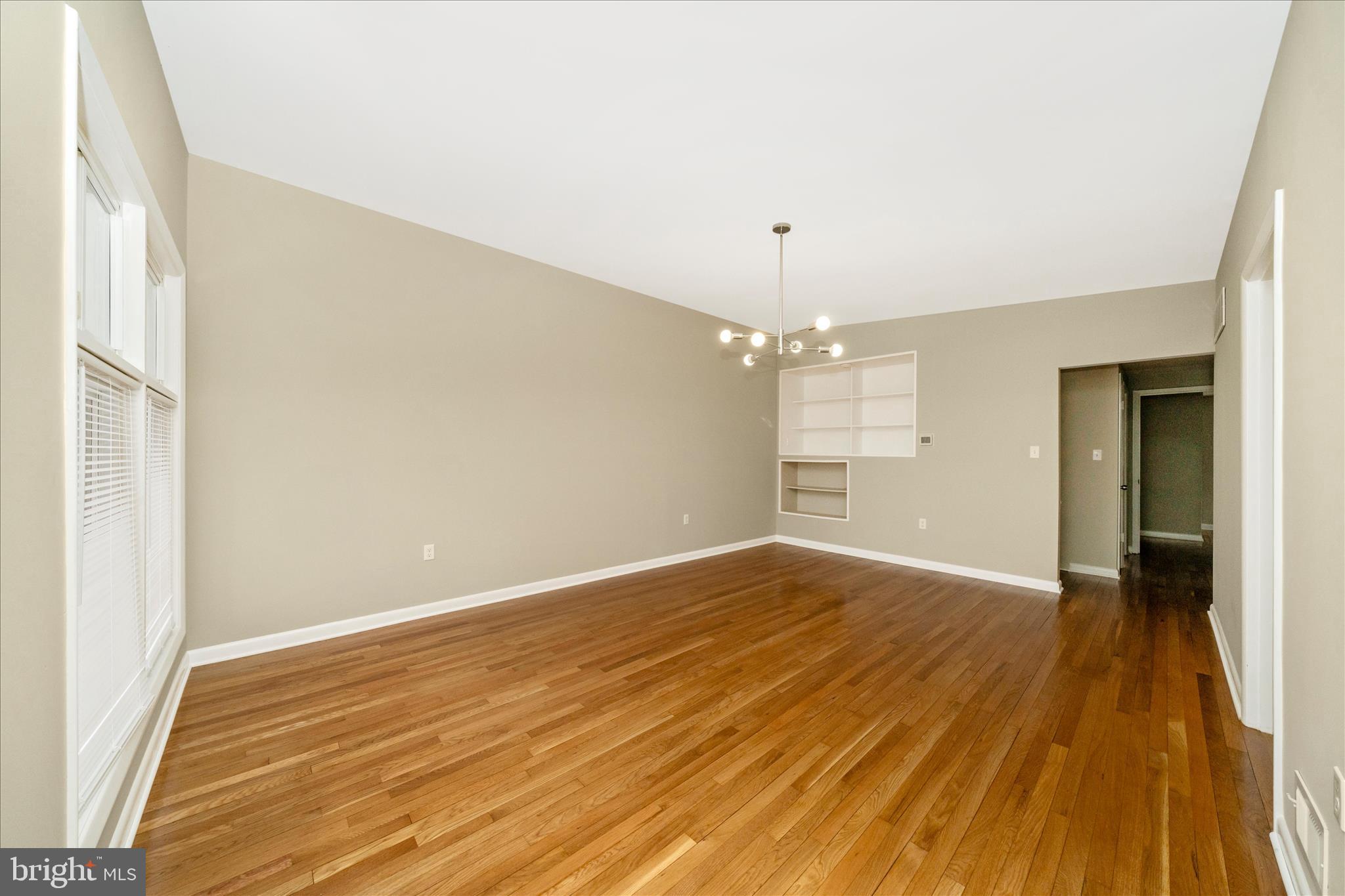 1302 Glenmont Road Baltimore, MD 21239 - Photo 11 of 49 an empty room with wooden floor and windows