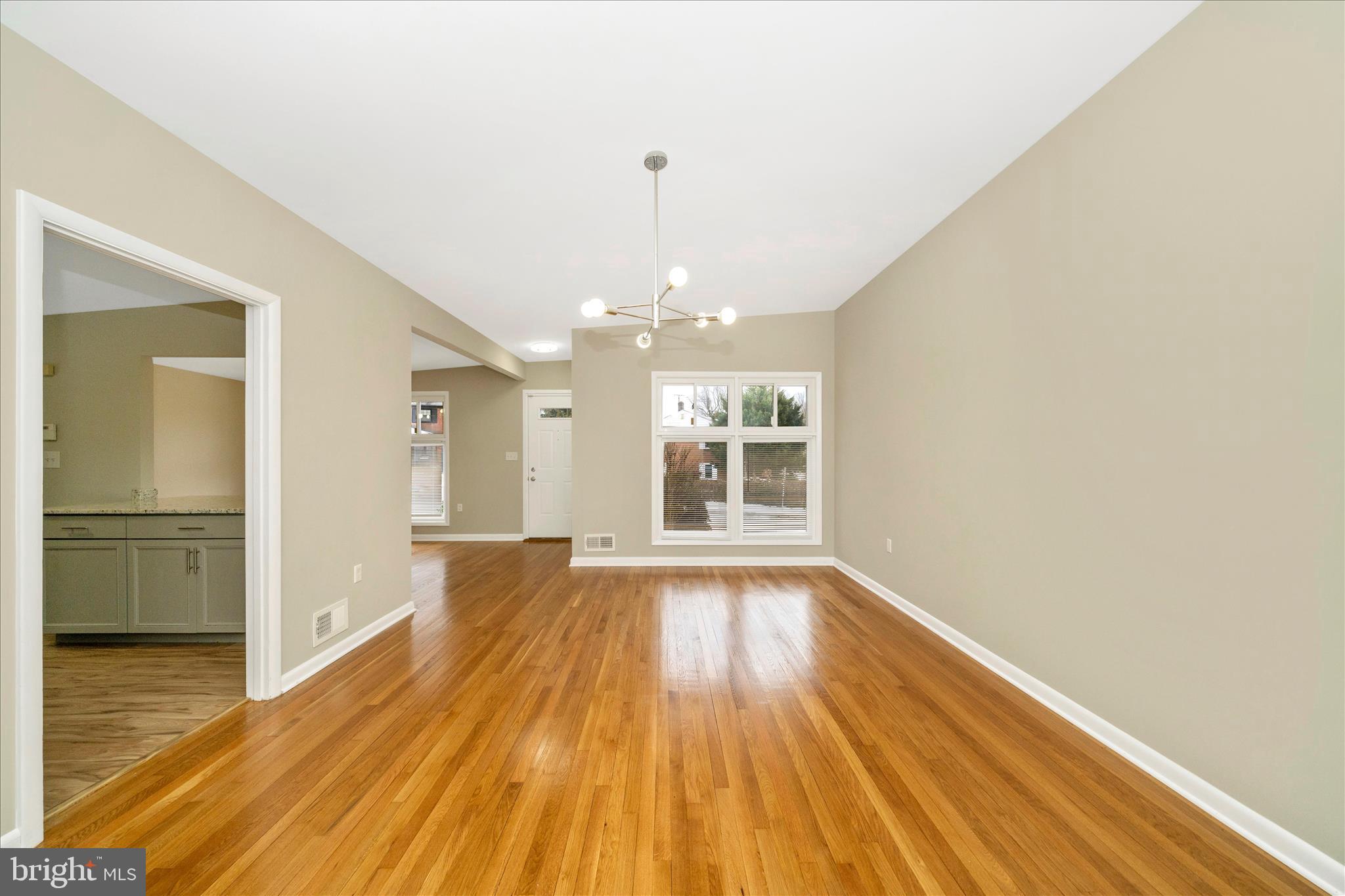 1302 Glenmont Road Baltimore, MD 21239 - Photo 14 of 49 a view of an empty room with wooden floor and a window