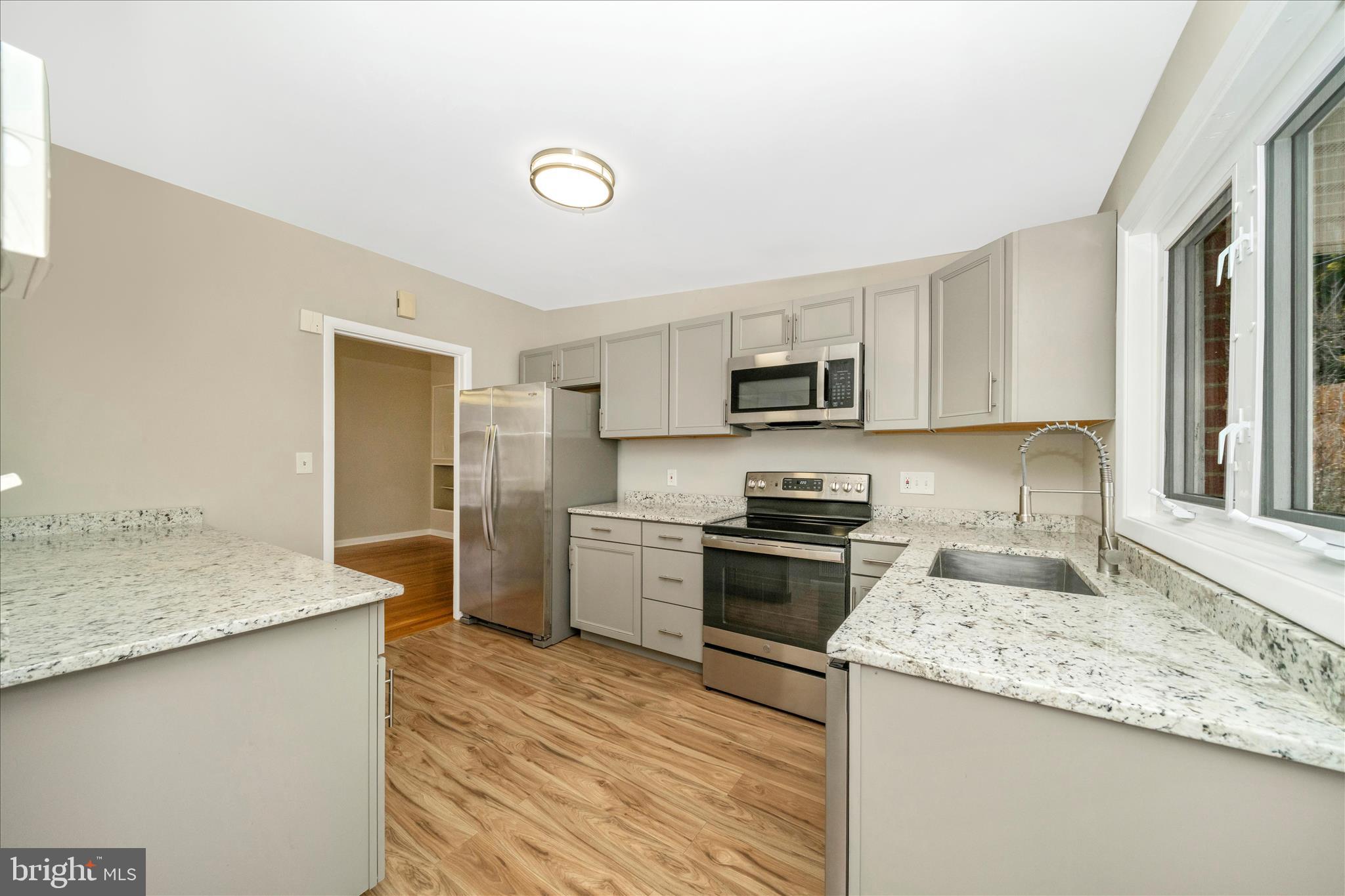 1302 Glenmont Road Baltimore, MD 21239 - Photo 15 of 49 a kitchen with granite countertop a sink stove and refrigerator