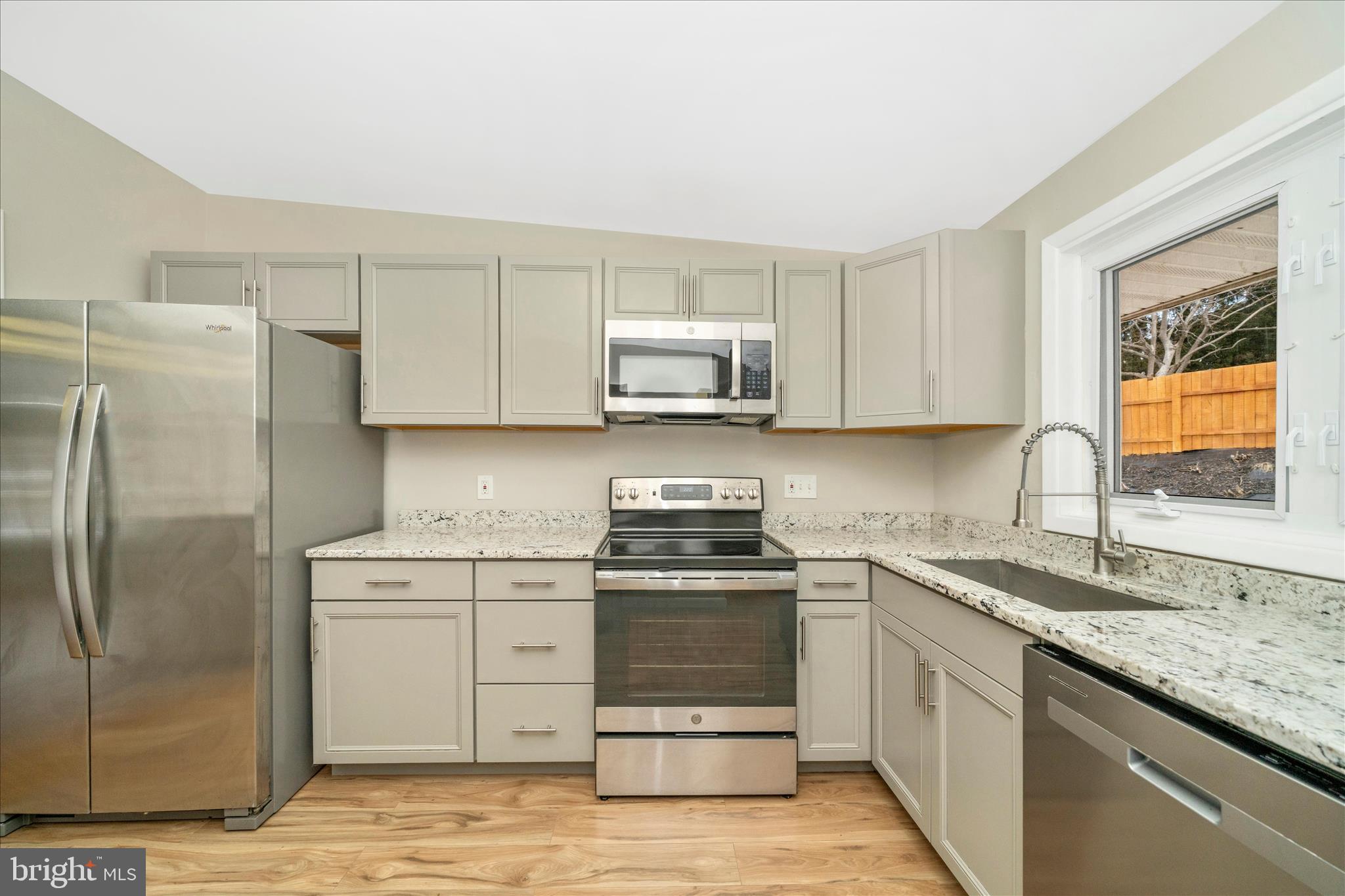 1302 Glenmont Road Baltimore, MD 21239 - Photo 17 of 49 a kitchen with stainless steel appliances granite countertop a stove a sink and a refrigerator