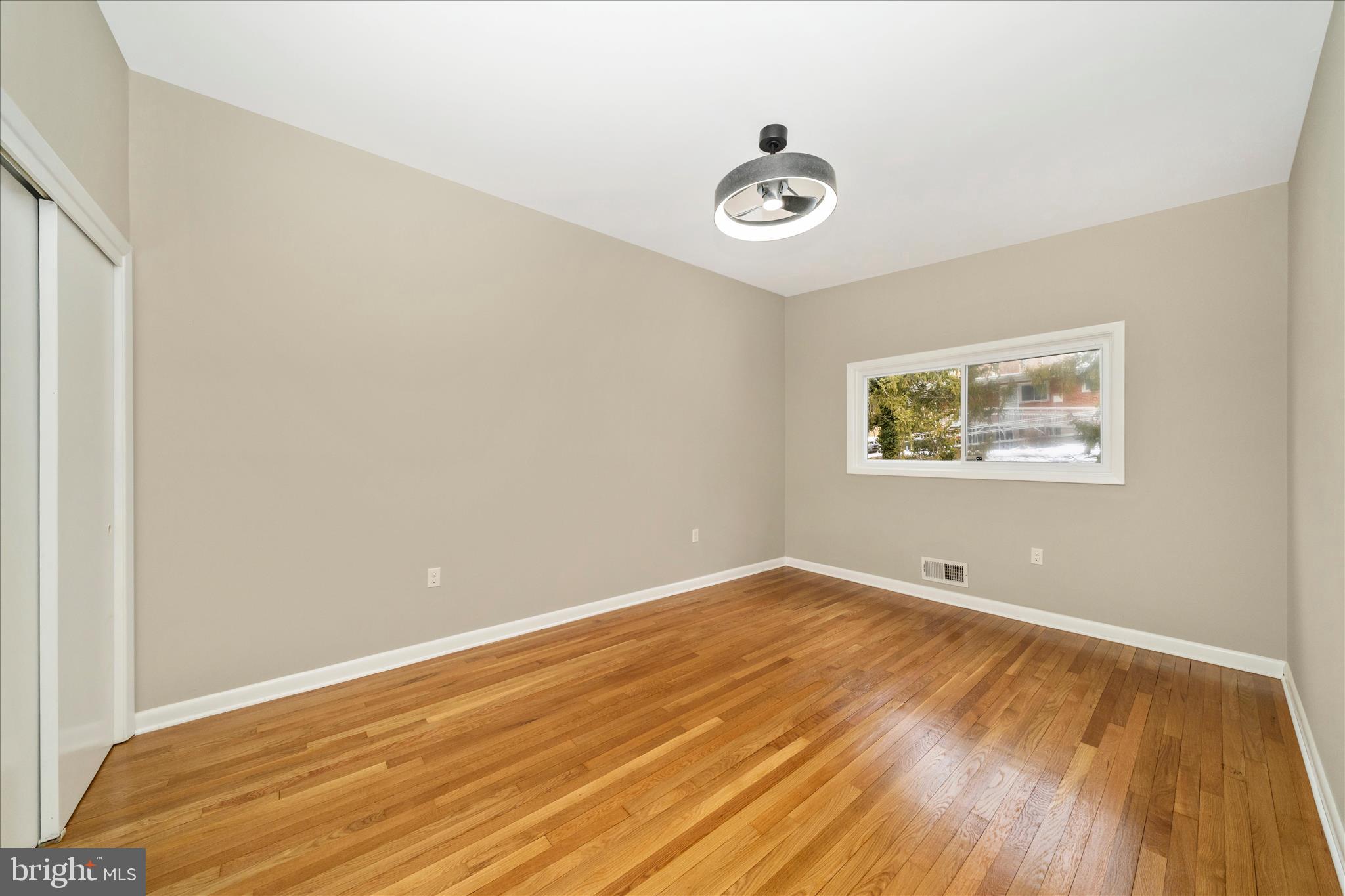 1302 Glenmont Road Baltimore, MD 21239 - Photo 21 of 49 an empty room with wooden floor and windows