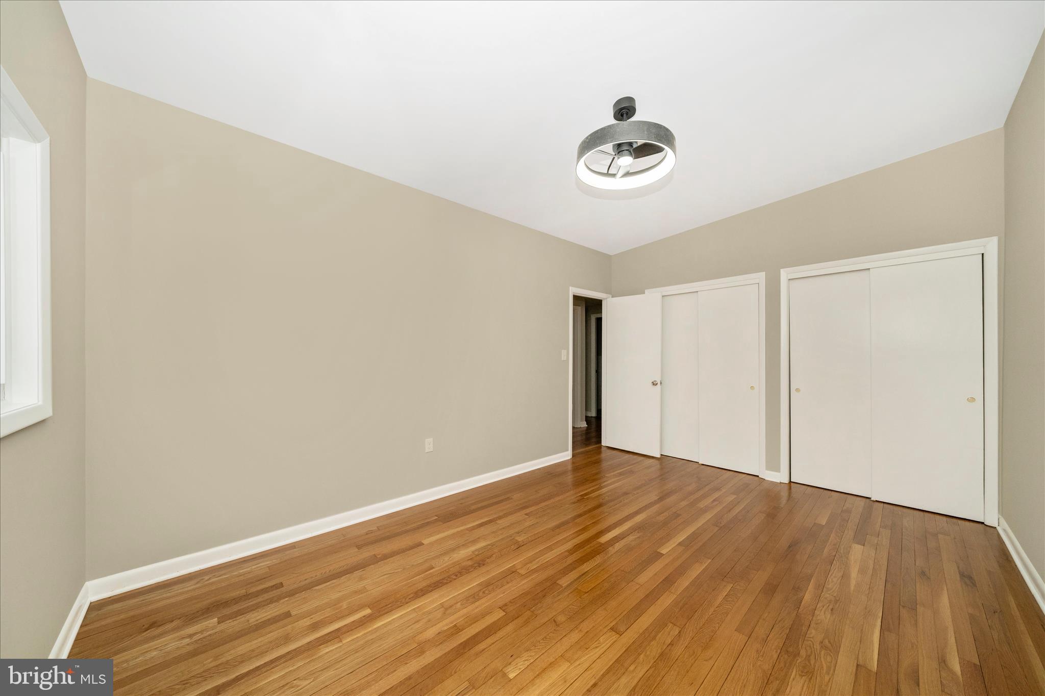 1302 Glenmont Road Baltimore, MD 21239 - Photo 23 of 49 an empty room with a hardwood and ceiling fan