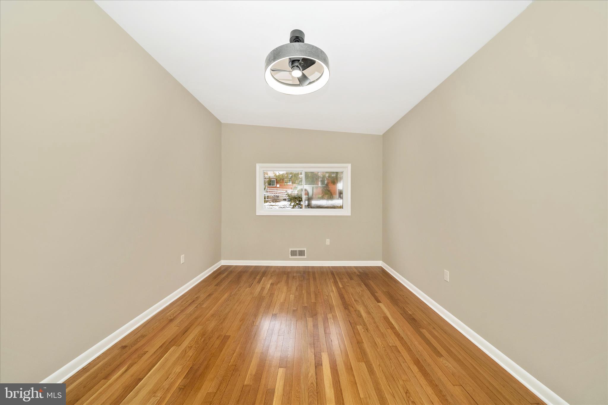 1302 Glenmont Road Baltimore, MD 21239 - Photo 24 of 49 an empty room with wooden floor and windows