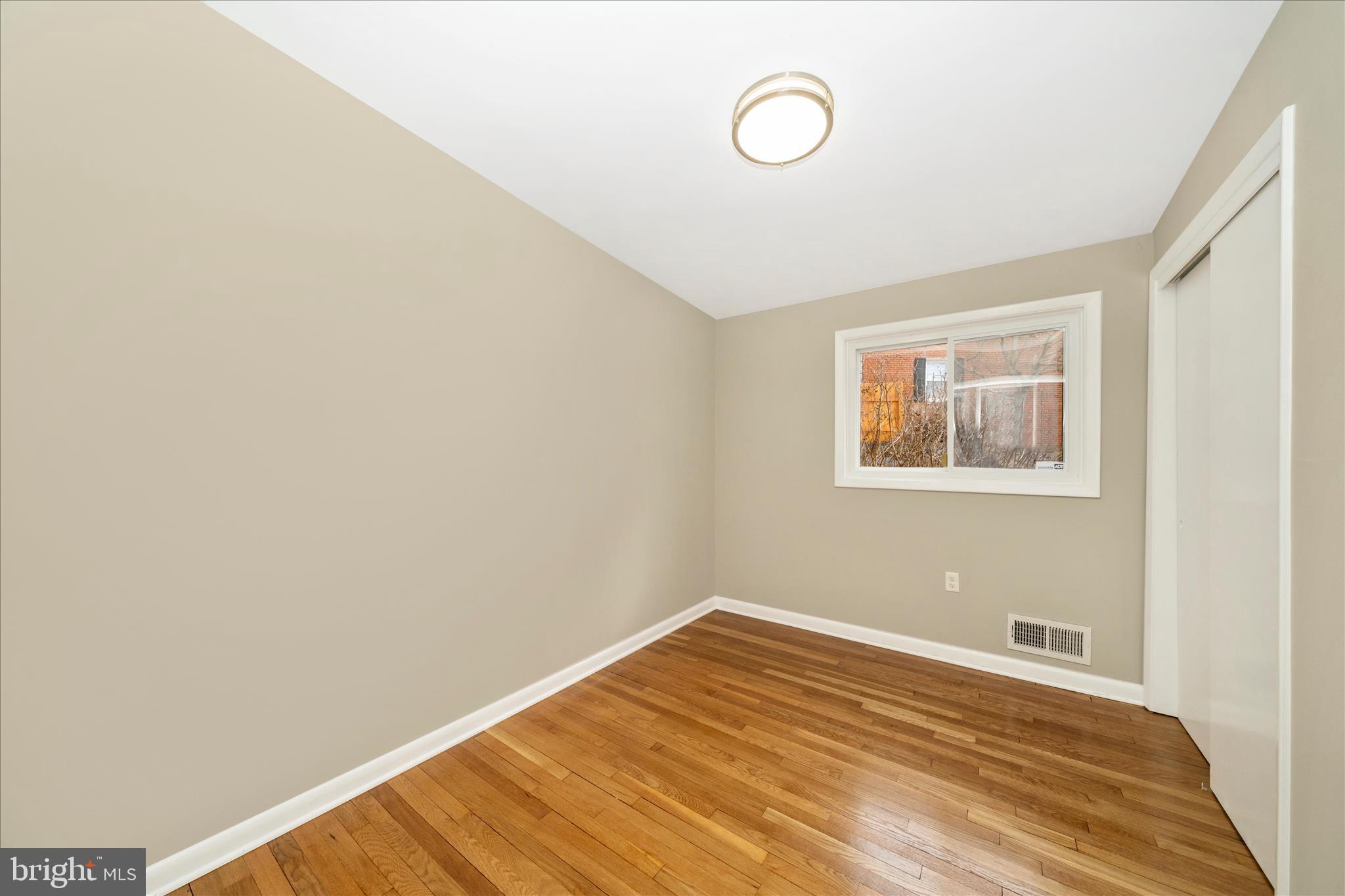 1302 Glenmont Road Baltimore, MD 21239 - Photo 25 of 49 a view of a room with wooden floor and white walls