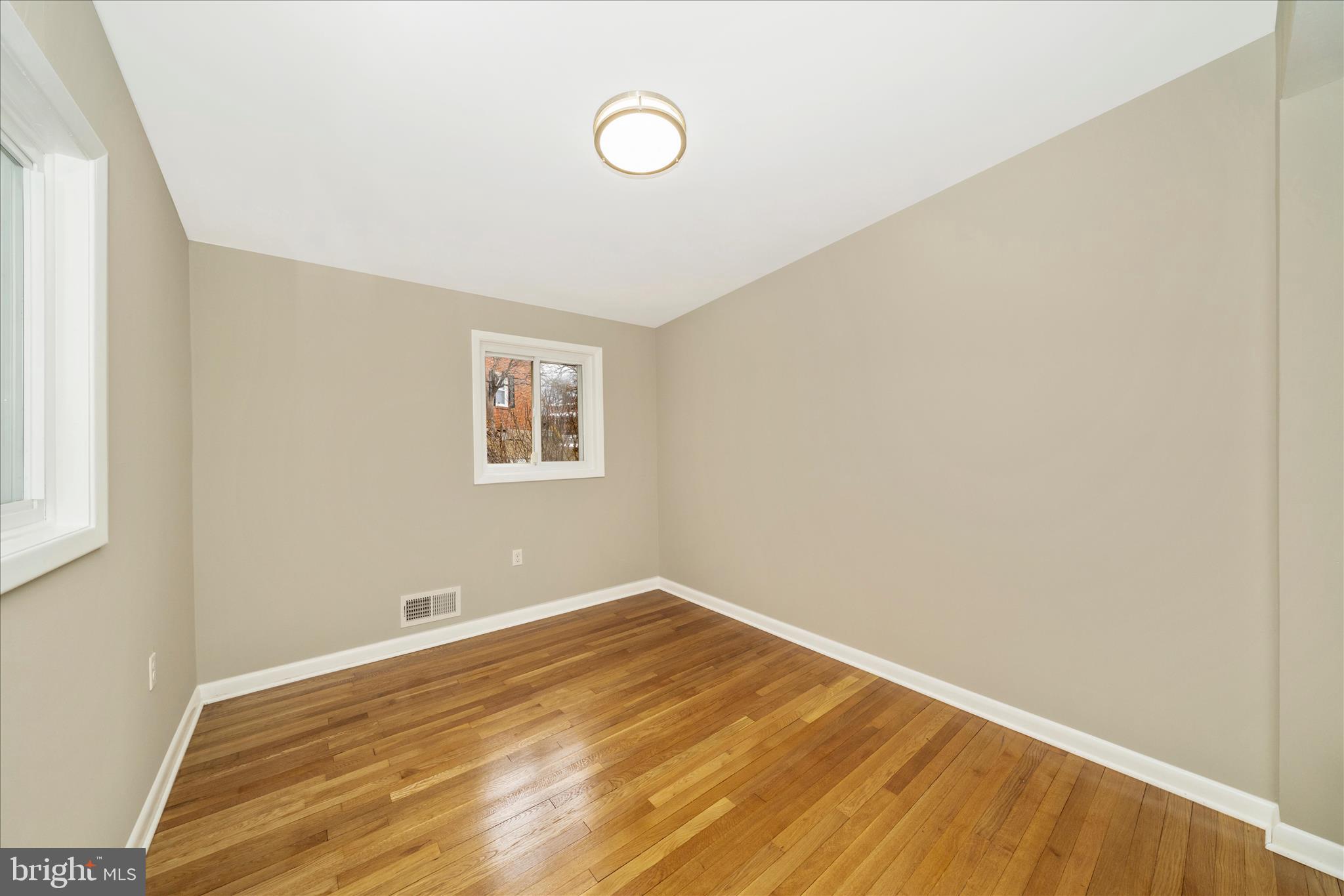 1302 Glenmont Road Baltimore, MD 21239 - Photo 29 of 49 a view of a room with wooden floor and white walls