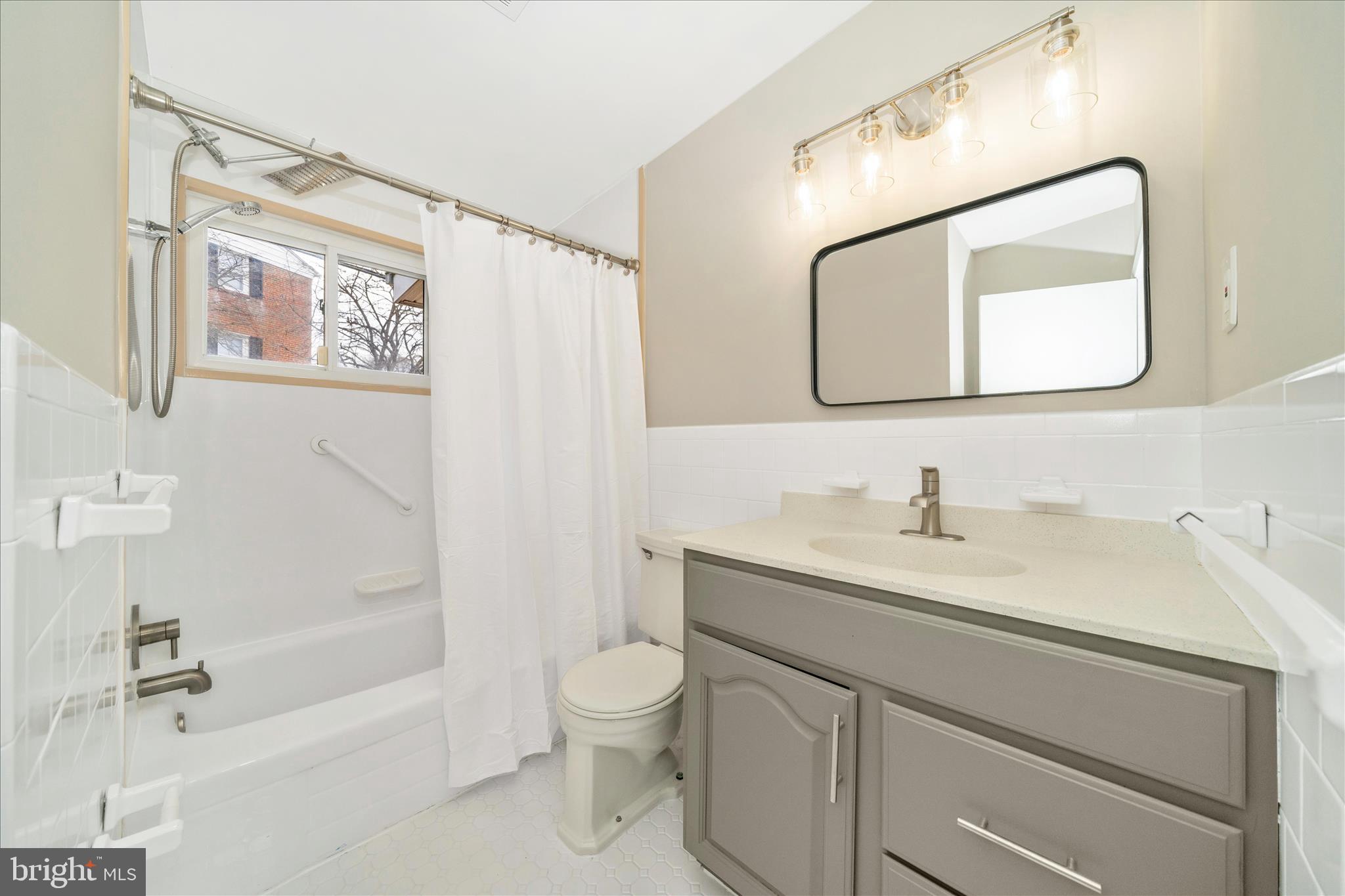 1302 Glenmont Road Baltimore, MD 21239 - Photo 31 of 49 a bathroom with a granite countertop sink mirror vanity and toilet