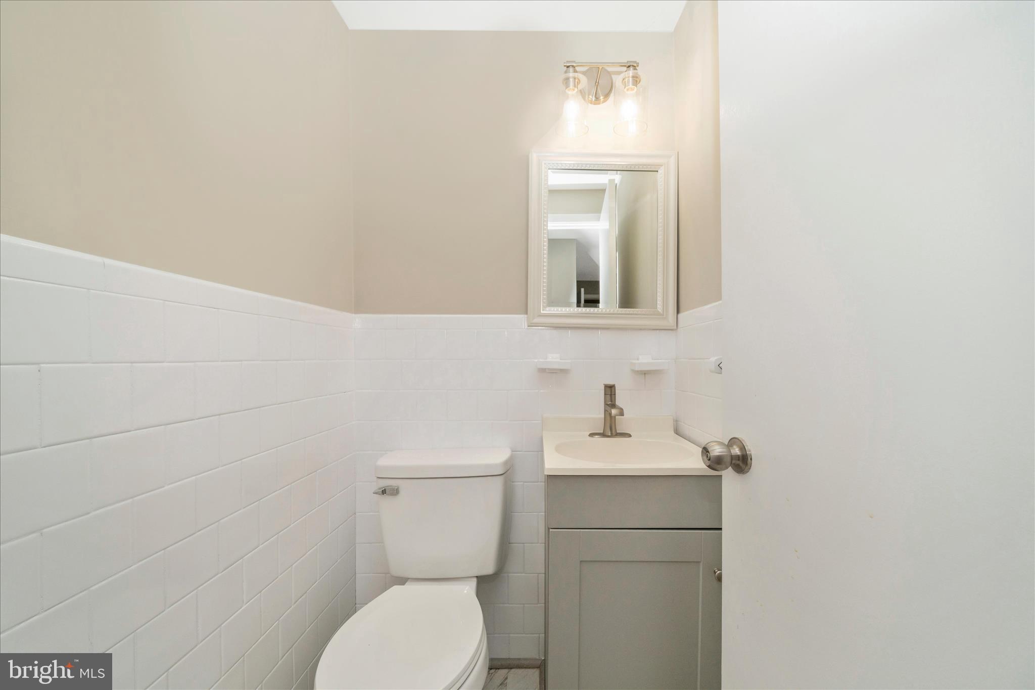 1302 Glenmont Road Baltimore, MD 21239 - Photo 32 of 49 a bathroom with a toilet sink and mirror