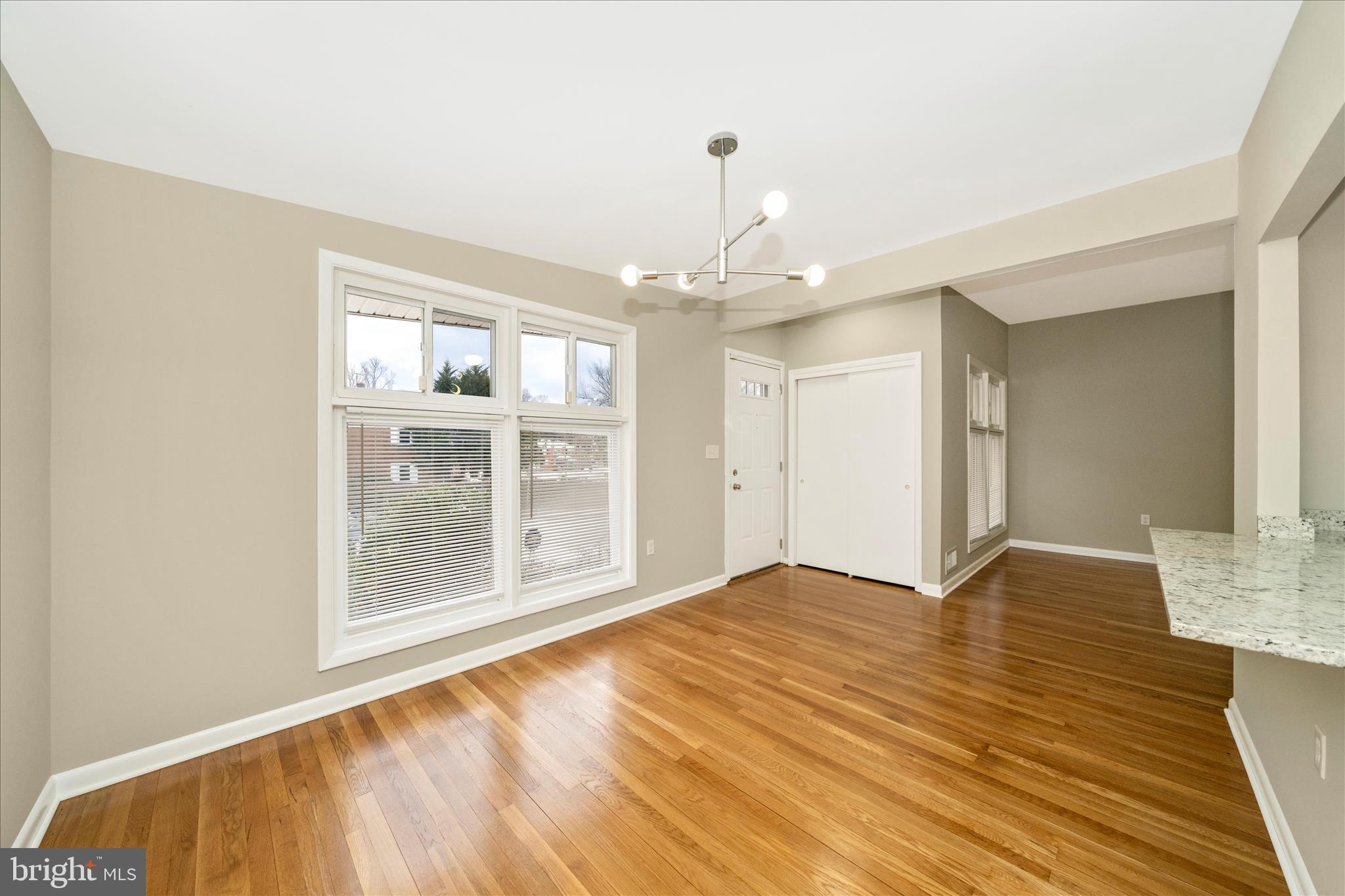 1302 Glenmont Road Baltimore, MD 21239 - Photo 4 of 49 a view of an empty room with wooden floor and a window