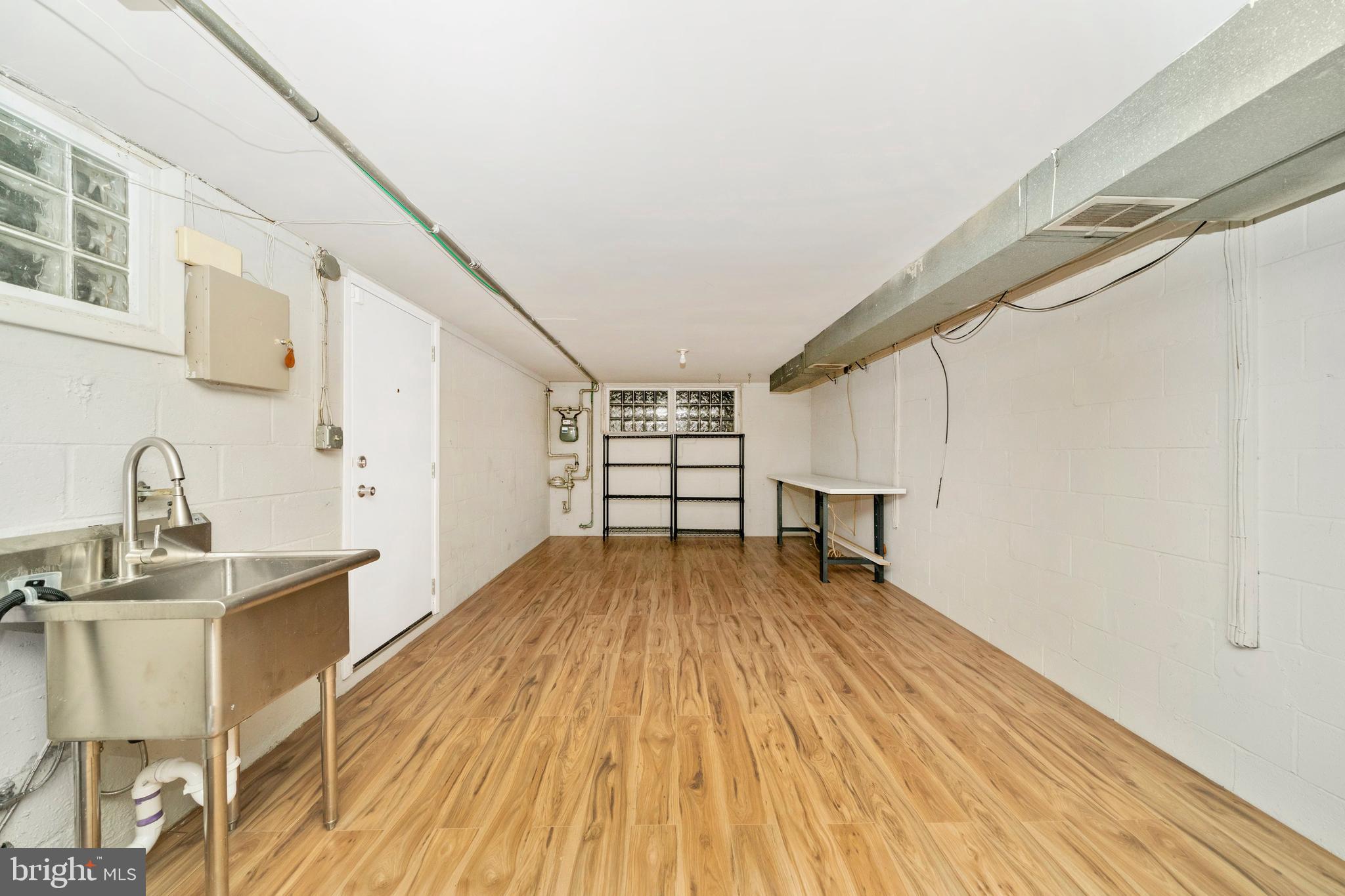 1302 Glenmont Road Baltimore, MD 21239 - Photo 46 of 49 a view of empty room with wooden floor and cabinet
