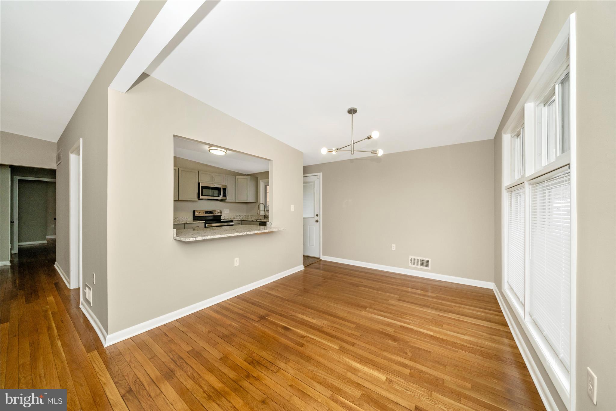 1302 Glenmont Road Baltimore, MD 21239 - Photo 5 of 49 a view of a room with wooden floor and a ceiling fan