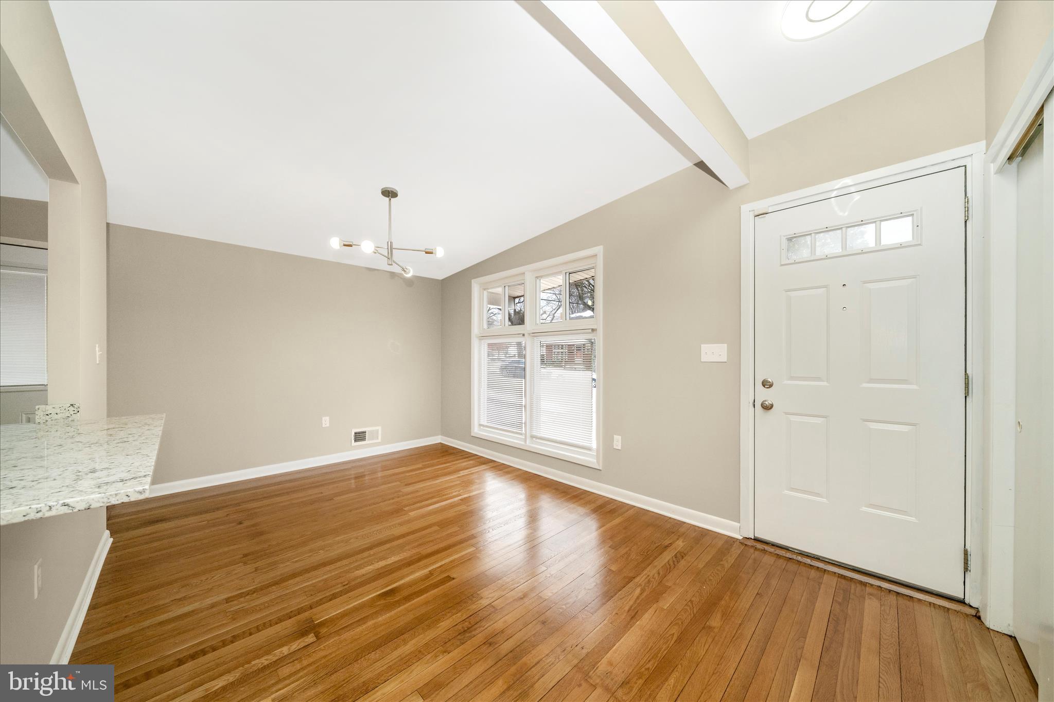 1302 Glenmont Road Baltimore, MD 21239 - Photo 6 of 49 an empty room with wooden floor and windows