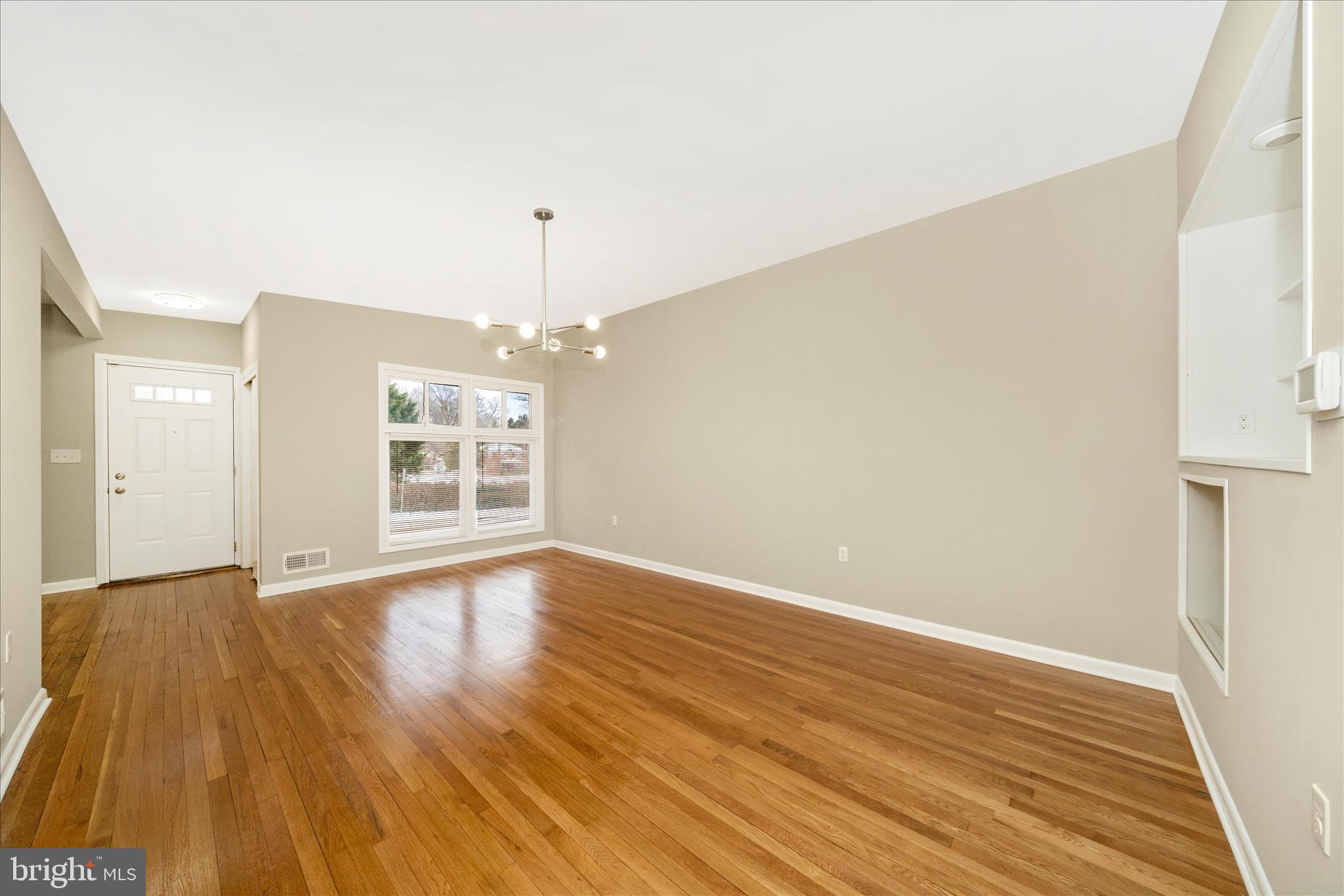 1302 Glenmont Road Baltimore, MD 21239 - Photo 9 of 49 wooden floor in an empty room with a window