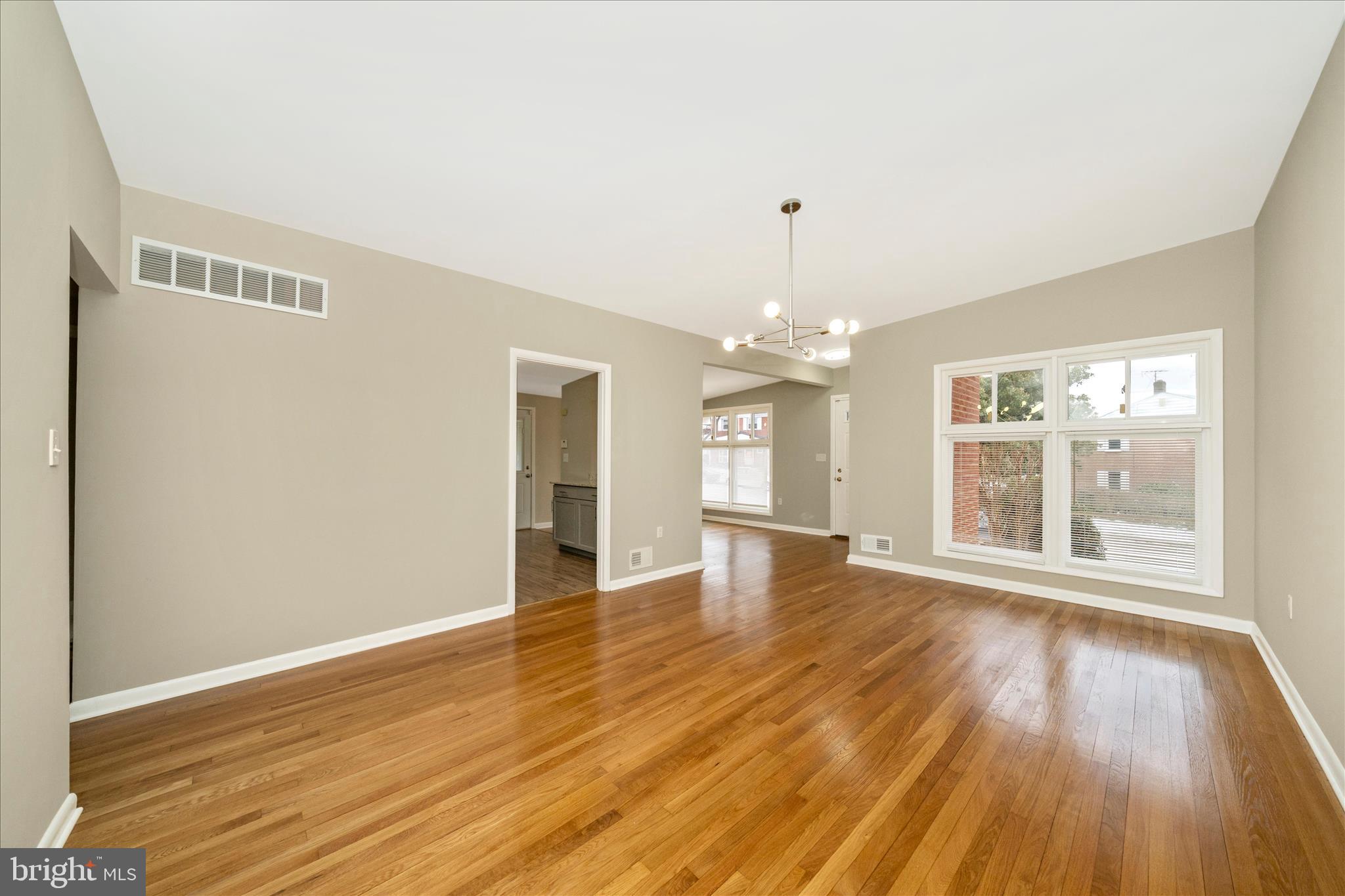 1302 Glenmont Road Baltimore, MD 21239 - Photo 10 of 49 a view of an empty room with wooden floor and a window
