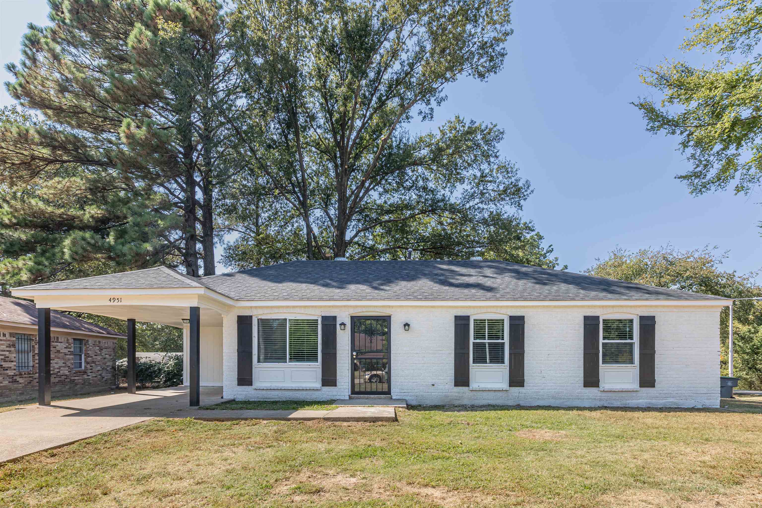 a front view of a house with a garden and tree