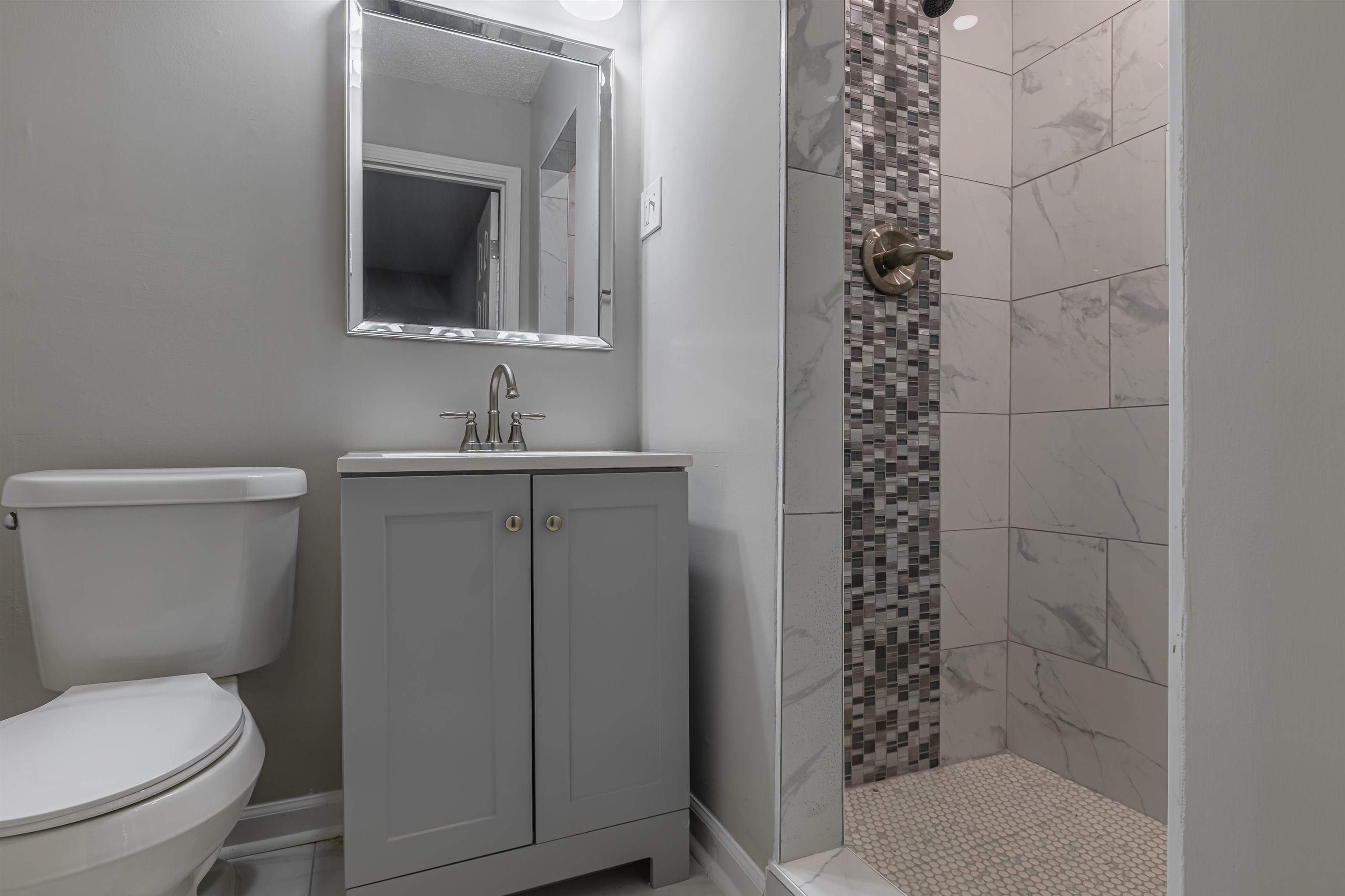 4951 Rosefield Road Memphis, TN 38118 - Photo 16 of 20 a bathroom with a toilet a sink and mirror