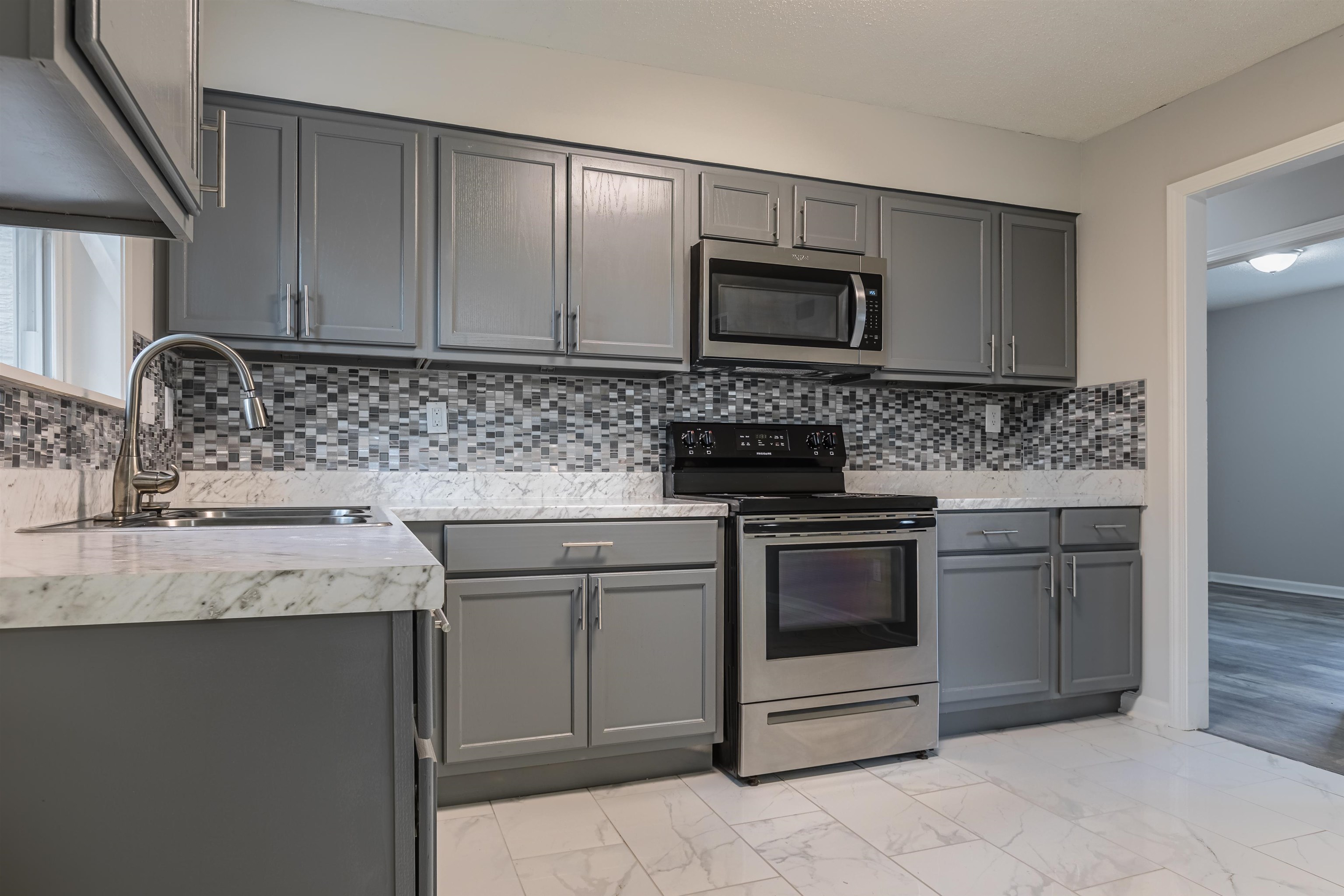 4951 Rosefield Road Memphis, TN 38118 - Photo 5 of 20 a kitchen with stainless steel appliances granite countertop a sink stove and microwave