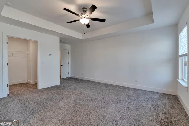 a en suite bathroom with a granite countertop sink a mirror and shower