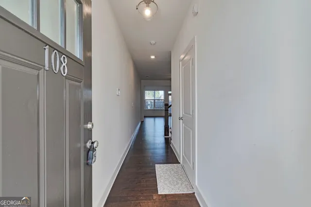 an empty room with wooden floor fireplace and windows