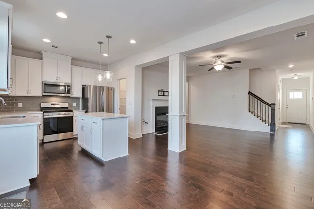 a kitchen with stainless steel appliances a refrigerator sink and white cabinets