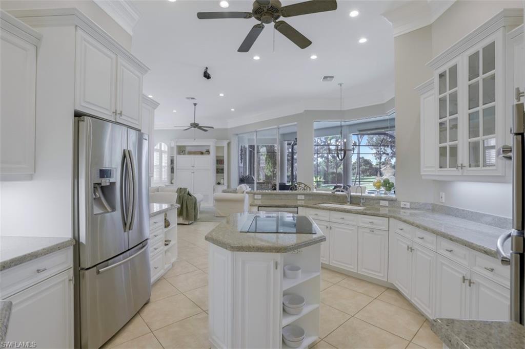 183 Audubon Boulevard Naples, FL 34110 - Photo 12 of 35 a kitchen with stainless steel appliances kitchen island granite countertop a refrigerator and a sink