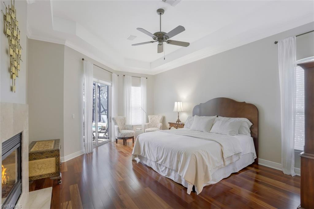 183 Audubon Boulevard Naples, FL 34110 - Photo 18 of 35 a bedroom with a bed and wooden floor