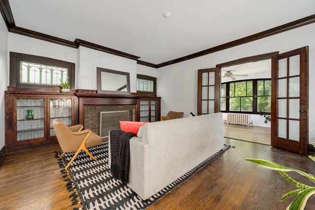 a living room with furniture a fireplace and a large window