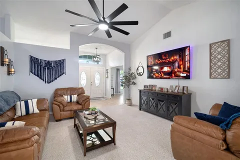 a living room with furniture a rug and kitchen view