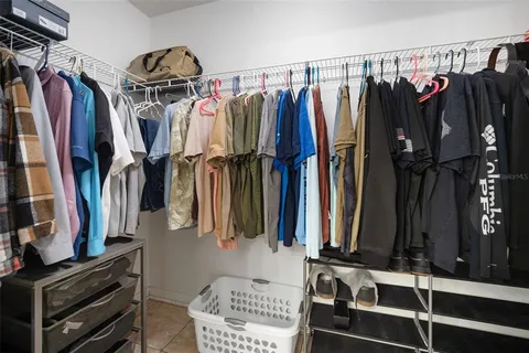 an empty room with chandelier fan and windows