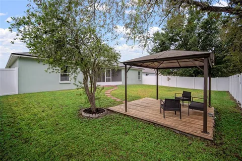 a view of a chair and table in backyard of the house