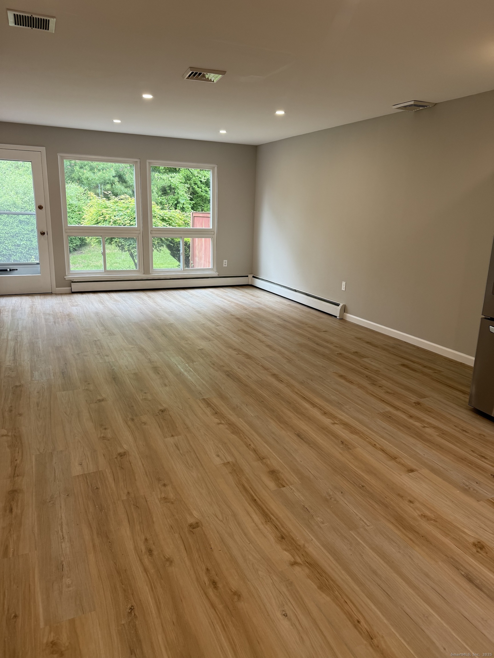 240 Centerbrook Road, Unit 240 Hamden, CT 06518 - Photo 8 of 26 an empty room with wooden floor and windows