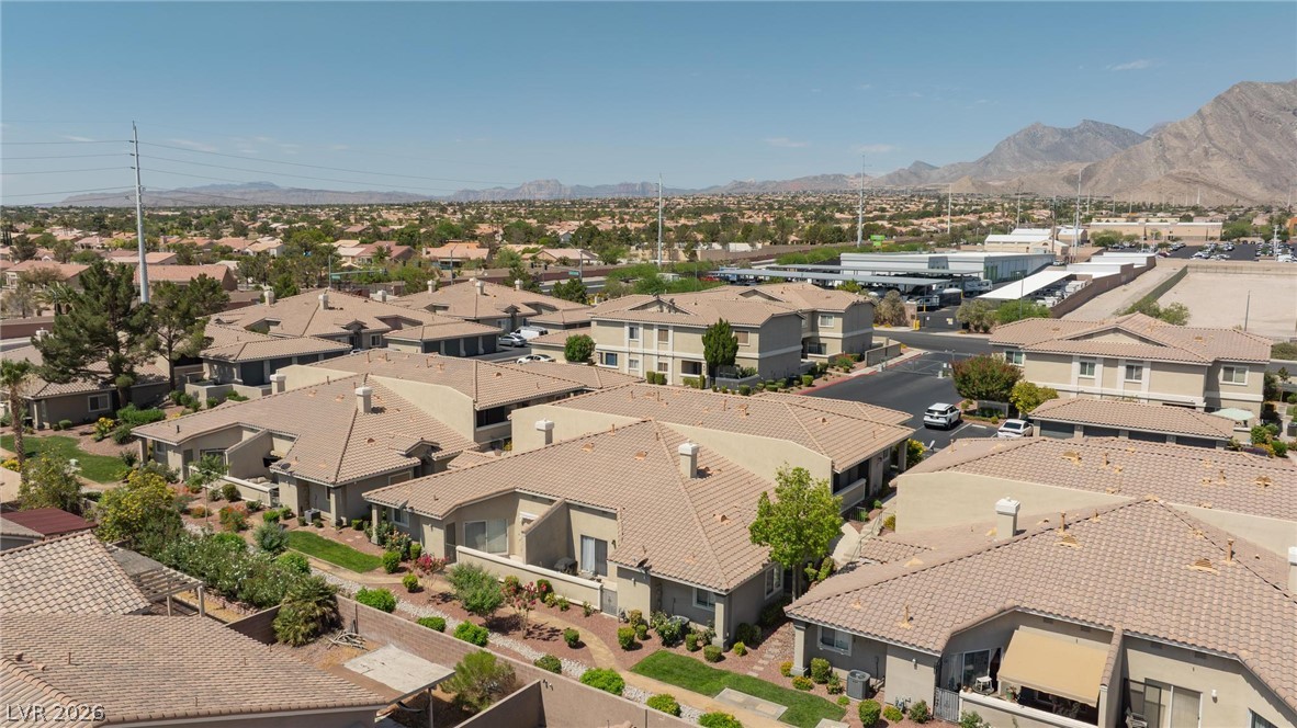 3238 Mystic Ridge Court Las Vegas, NV 89129 - Photo 31 of 31 An aerial perspective reveals a well-maintained community of homes under a bright sky, framed by distant mountains.