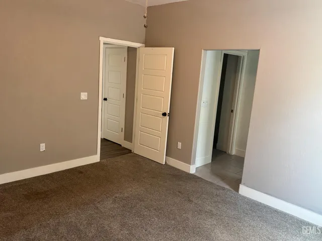 an empty room with closet and a bathroom