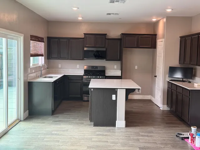 a kitchen with stainless steel appliances granite countertop a stove a sink and a refrigerator