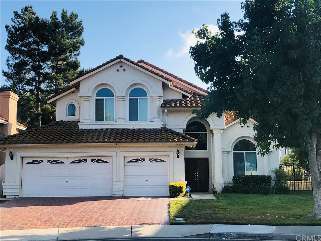 a front view of a house with a garden and trees