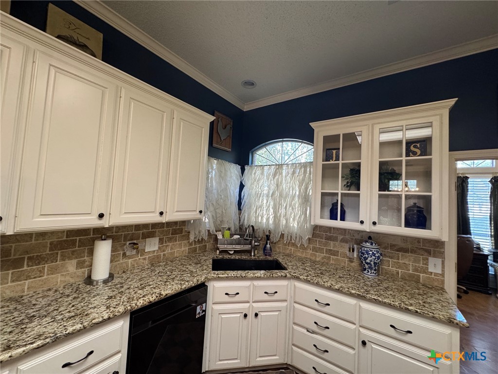 115 Oak Ridge Road Gatesville, TX 76528 - Photo 14 of 37 a kitchen with granite countertop a sink and cabinets