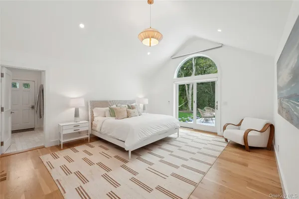 a spacious bedroom with a bed a table and a large window