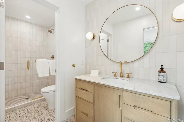 a bathroom with a sink a toilet and a mirror